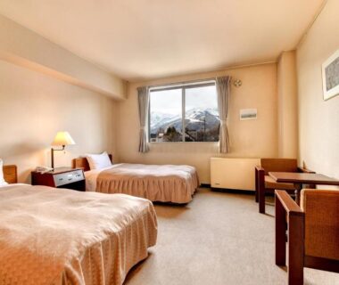 Twin beds, desk, and window with mountain view at Hotel La Montagne Furuhata, Nagano