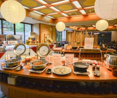 Buffet spread on central wooden island in tatami dining room at Hotel Manyotei, Tochigi, Kantō, Japan