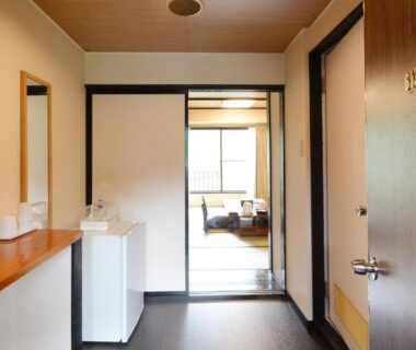 Hallway with wooden counter and sliding shoji leading to a tatami room at Hotel Manyotei in Tochigi