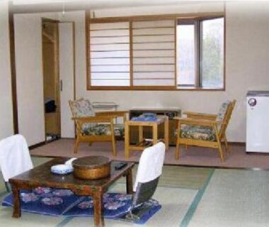 Traditional tatami room with low table, zabuton cushions and window seating at Hotel Masyu, Hokkaidō