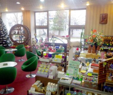 Indoor ryokan gift shop with seating, displays, Christmas tree and souvenir shelves at Hotel Masyu in Hokkaidō