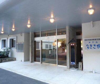 Covered glass entrance with lit canopy and signage at Hotel Nagisaya in Wakayama, Kansai