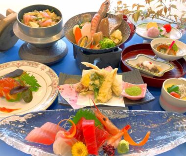 Assorted Japanese dishes: sashimi, tempura, small bowls and rice pot arranged on table for ryokan meal