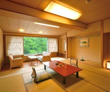 Traditional tatami room with low table, floor cushions and window seating at Hotel New Mitoya, Miyagi