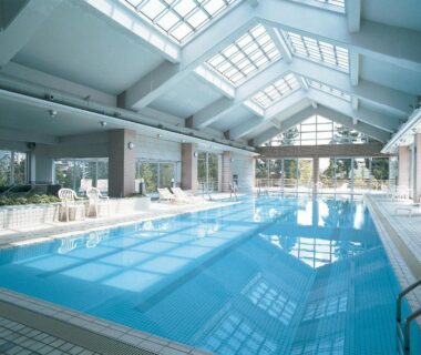 Bright tiled indoor pool with skylights and lounge chairs at Hotel New Mitoya in Miyagi Tohoku Japan