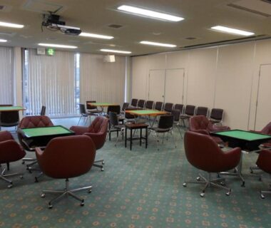 Recreation room with green game tables, red swivel chairs and carpet at Hotel New Momiji, Tochigi
