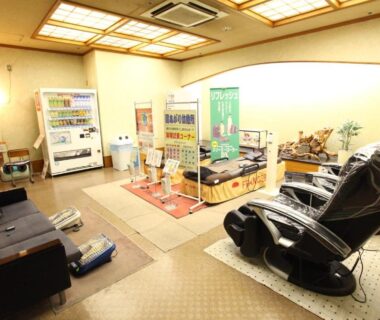 Carpeted relaxation lounge with massage chairs and vending machines at Hotel New Ohruri in Tochigi