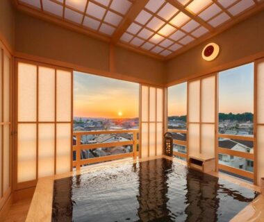 Indoor onsen with wooden tub, shoji screens and sunset town view at Hotel New Wakasa in Nara