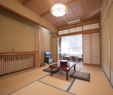 Traditional tatami room with low table, zabuton cushions and shoji screens at Hotel Nosegawa in Nara