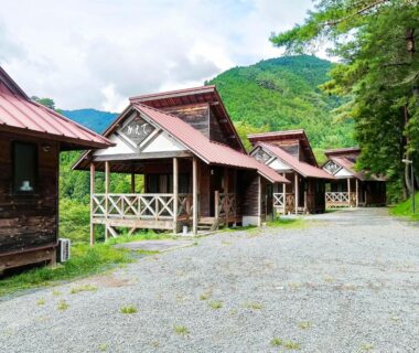 Row of wooden cottages with mountain backdrop at Hotel Nosegawa in Nara, Kansai, Japan