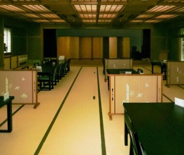 Spacious tatami dining hall with low tables and wooden partitions at Hotel Nosegawa in Nara, Kansai
