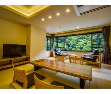 Tatami room with low wooden table and forest view at Hotel Okuyumoto in Kanagawa