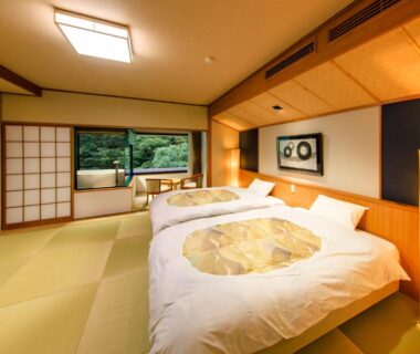 Tatami room with twin beds, shoji screens and garden view at Hotel Okuyumoto in Kanagawa