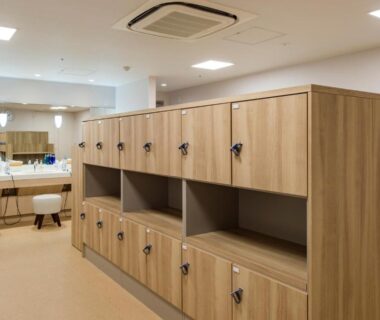 Changing room with wooden lockers, mirrors and vanity counters at Hotel Ole in Shizuoka