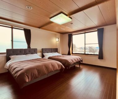 Two western beds with adjacent tatami area in Hotel Omodaka guest room, Nagano, Chūbu