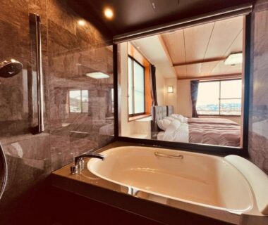 Marble bathroom bathtub overlooking bedroom at Hotel Omodaka, Nagano