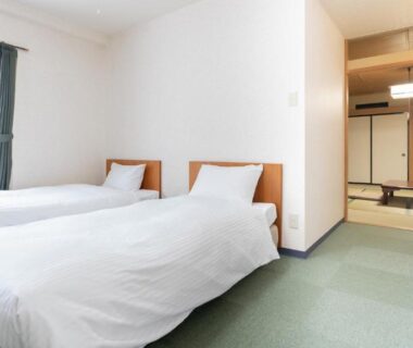 Room with twin beds and adjoining tatami area with low table and shoji at Hotel & Onsen 2307 Shigakogen Nagano