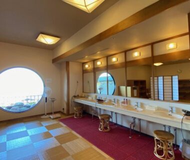 Communal vanity counter with mirrors and round window at Hotel Oosado, Niigata, Chūbu
