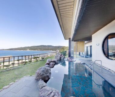 Outdoor stone-lined onsen overlooking the sea at Hotel Oosado in Niigata Chūbu