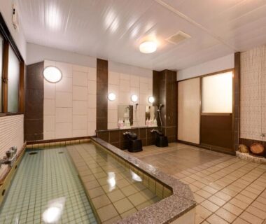 Tiled indoor communal bath with washing stations at Hotel Oumiya Kyoto