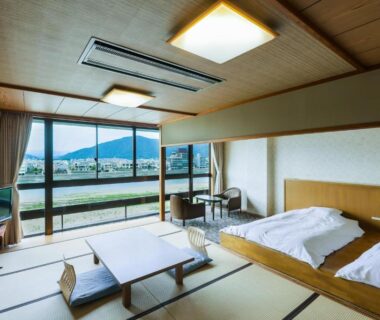 Spacious tatami room with low table, twin beds and large windows at Hotel Park in Gifu, Chūbu, Japan