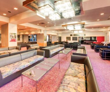 Large carpeted lounge with sofas and glass tables at Hotel Ravie Kawaryo in Shizuoka Chūbu
