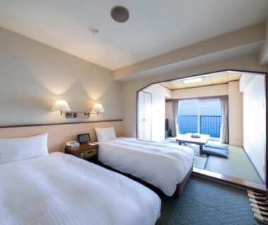 Twin room with tatami seating area, low table and bedside lamps at Hotel Resorpia Atami Shizuoka