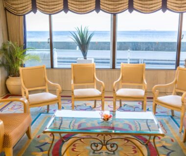 Lounge chairs and glass table facing ocean at Hotel Resorpia Atami in Shizuoka, Chubu, Japan