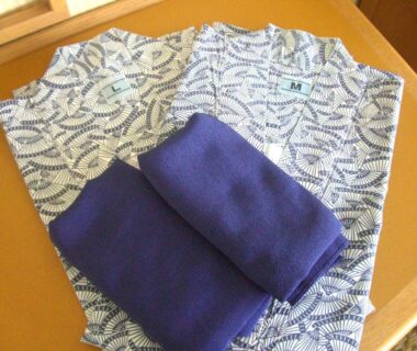 Folded yukata with navy sashes on wooden table at Hotel Resorpia Atami, Shizuoka