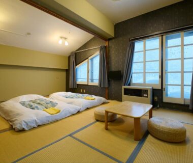 Traditional tatami room with futon bedding and low table at Hotel ST MORITZ in Niigata