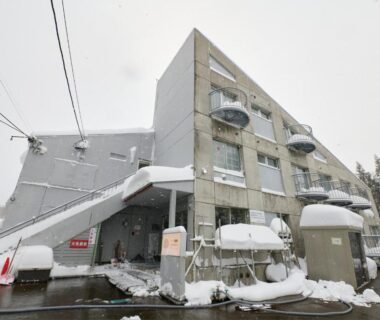 Snow-covered exterior of Hotel ST MORITZ with balconies and entrance in Niigata, Chūbu Japan