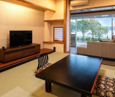 Tatami room with low table, sofa and sliding balcony door at Hotel Saginoyu, Nagano, Chūbu