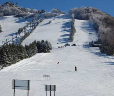 Ski slope with skiers and lifts on a snow-covered mountain near Hotel Sanraku, Nagano, Chūbu