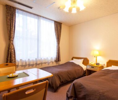 Twin beds, table and lamp in guest room at Hotel Seikoen, Tochigi Kantō