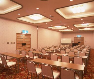 Banquet-style conference room with rows of tables and projector screen at Hotel Seikoen in Tochigi, Kantō