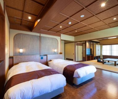 Twin Western beds adjacent to tatami seating and shoji screens at Hotel Sekitei in Yamanashi
