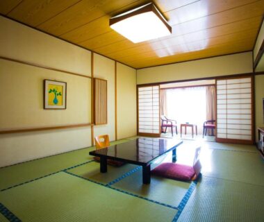 Traditional tatami room with low table, zabuton cushions, shoji screens and balcony seating at Hotel Sekitei, Yamanashi