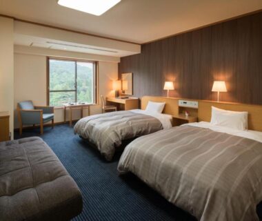 Twin beds, seating area, window with greenery at Hotel Senshukaku in Iwate, Tōhoku