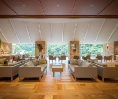 Airy lounge with sofas, wooden floors and large windows overlooking greenery at Hotel Shidotaira, Iwate, Tōhoku