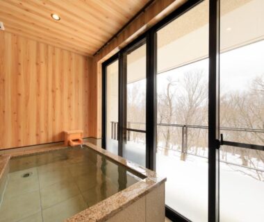 Indoor wooden bath with large windows overlooking snowy woods at Hotel Shikisai, Tochigi