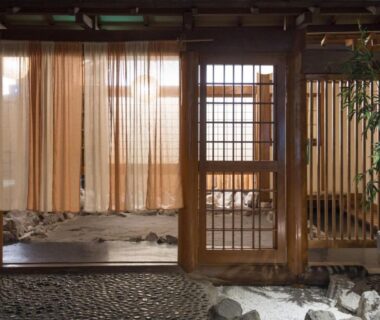 Traditional shoji doorway with noren curtains and stone entryway at Hotel Shirakawa Yunokura, Tochigi