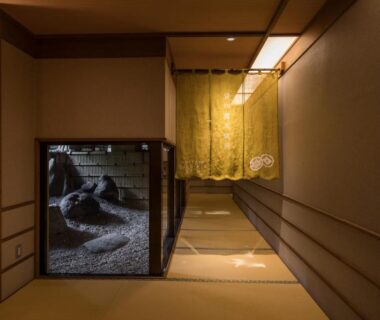 Tatami hallway with noren curtain and display case, warm wooden decor at Hotel Shirakawa Yunokura, Tochigi