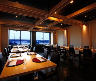 Interior dining room with wooden beams, table settings and large windows at Hotel Shosenkaku Romankan, Kumamoto