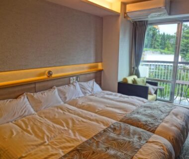 Twin beds with balcony seating and greenery view at Hotel Spax Kusatsu, Gunma, Kantō, Japan
