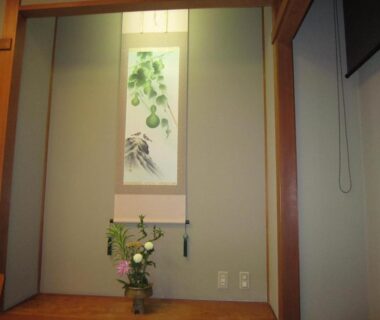 Tatami room tokonoma with hanging scroll and floral arrangement at Hotel Spax Kusatsu, Gunma