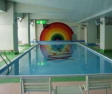 Indoor swimming pool with rainbow mural at Hotel Spax Kusatsu in Gunma, Kantō, Japan