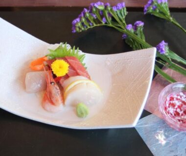 Fresh sashimi with scallop, wasabi and edible flower on white plate at Hotel Spax Kusatsu, Gunma