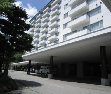 Multi-story hotel with balconies and covered entrance drive at Hotel Spax Kusatsu in Gunma