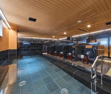 Communal bathing area with stools and shower faucets at Hotel Sugicho, Kyoto, Kansai, Japan