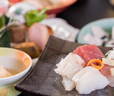 Sashimi assortment with small side dishes and garnish on lacquer table at a ryokan in Kyoto